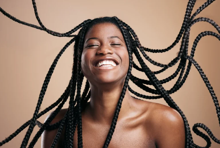 Attractive african woman with her braids bouncing in the air.